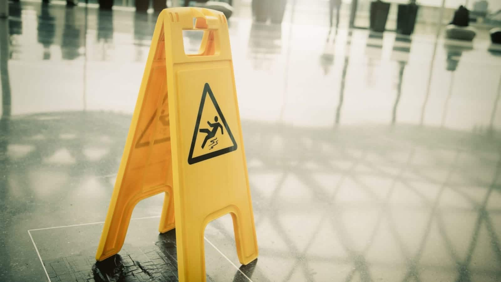 A yellow “Caution: Slippery Floor” sign.